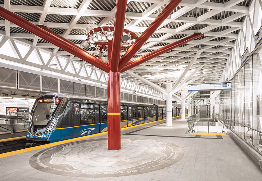 A bus driving past a bus stop in front of a forest