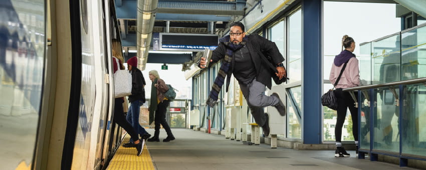A man running towards the train platform in a hurry.
