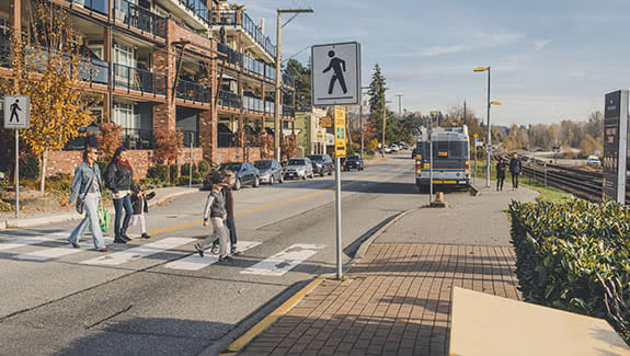 Pedestrians that include mothers and children crossing the street