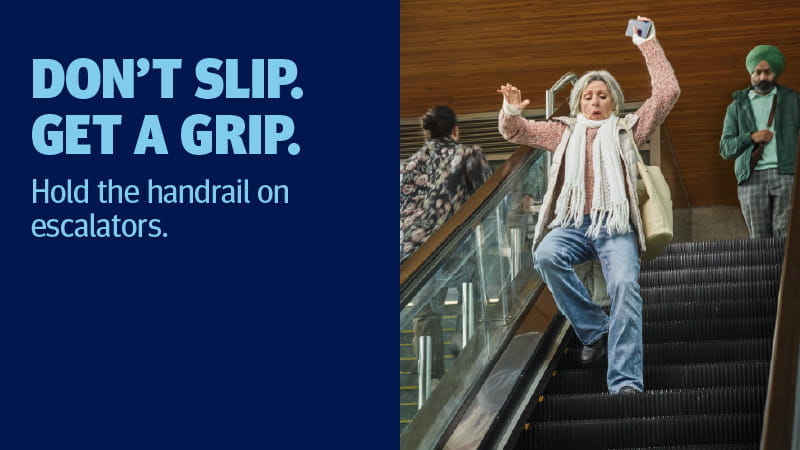 A woman on escalator not holding the handrail and losing balance.