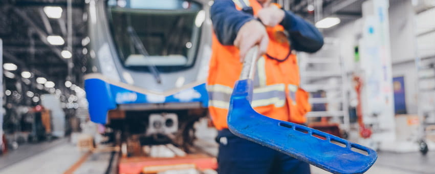 SkyTrain employee holds a plastic hockey stick in front of a SkyTrain